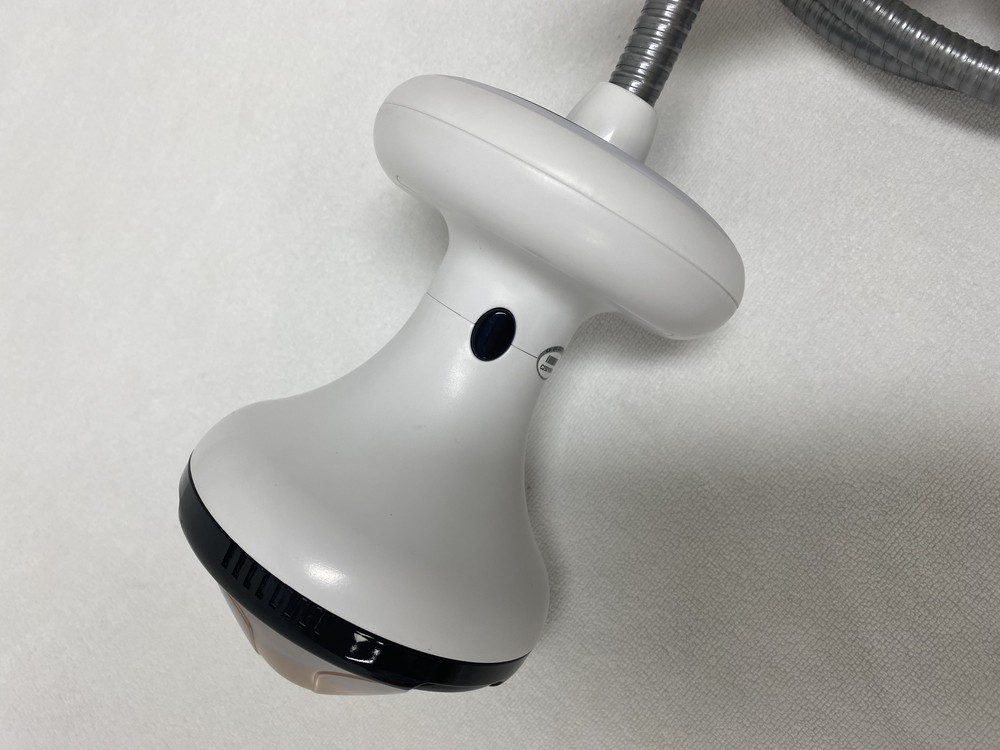 Close-up of a focused shockwave applicator, showing the treatment face, the connector and the flexible cable