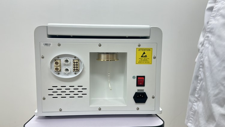 Rear panel of the focused shockwave unit showing the water reservoir window, the fill cap and the applicator connector