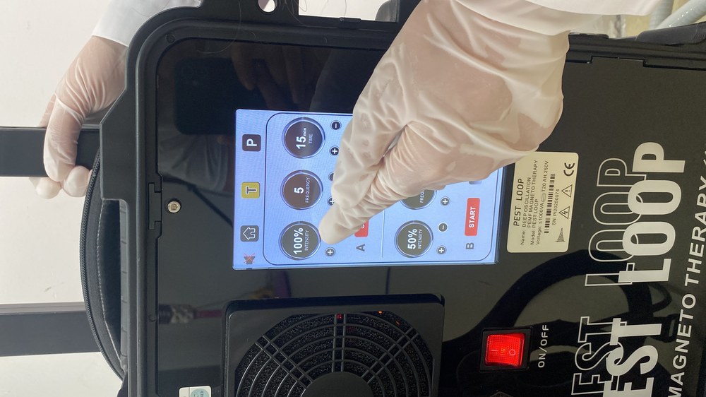 Therapist in gloves adjusting channel A intensity and frequency while channel B continues running on the same screen