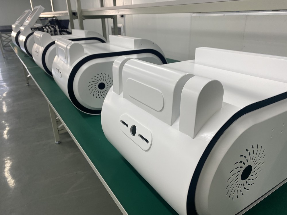 White TECAR units lined up on the production bench during assembly
